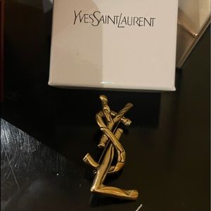 - YSL brooch. Dark gold
